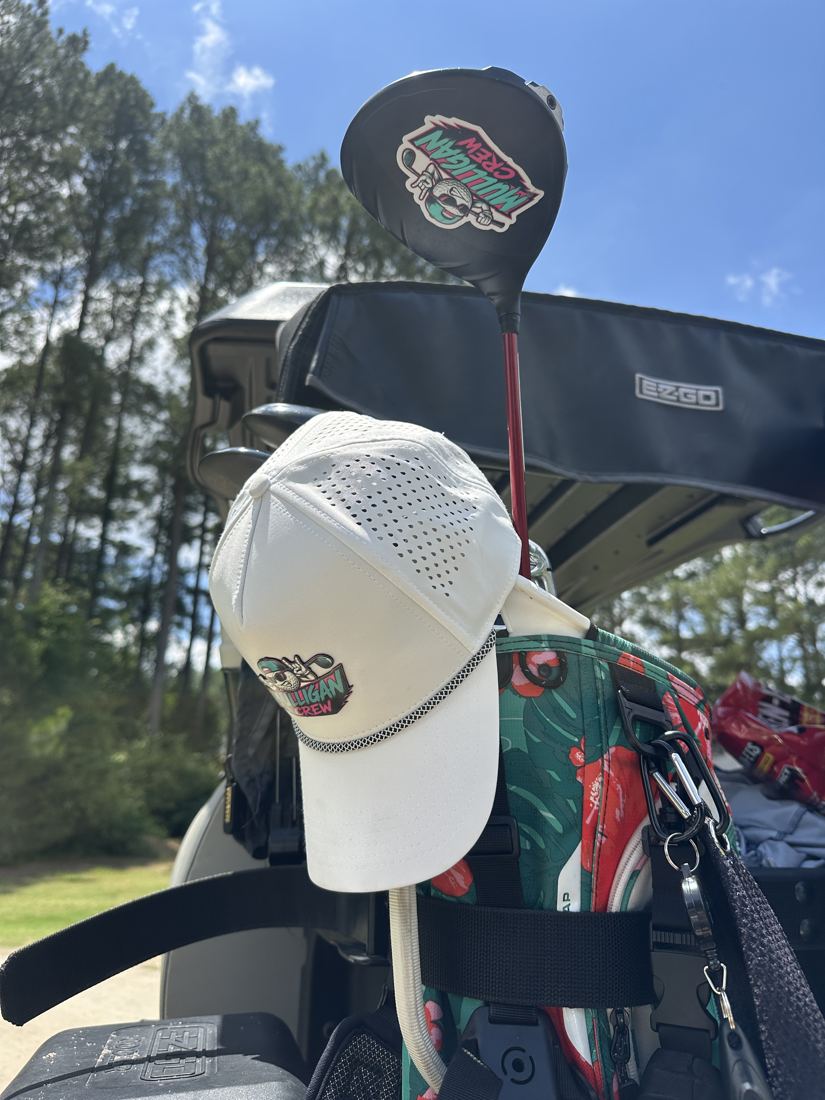 The Crew Hat hanging on a driver, Mulligan head cover behind